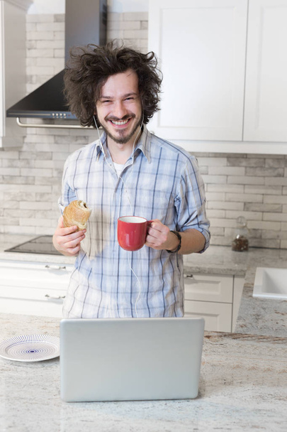 Man Eating Breakfast during Using Laptop - Foto, Bild