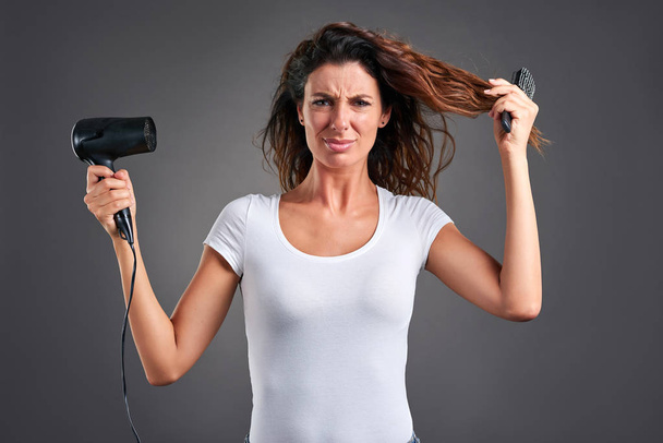Young woman with a hairdryer - Foto, immagini