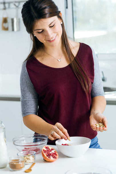 Beautiful young woman preparing cereal bowls in the kitchen. - Foto, imagen