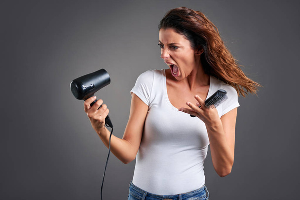 Young woman with a hairdryer 	 - Fotoğraf, Görsel
