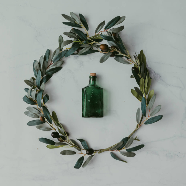 olijftakken met groene fles - Foto, afbeelding