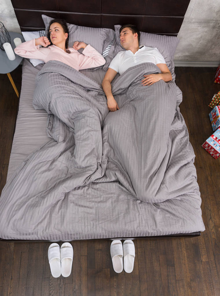 Fiatal pár felébredni az ágyban, és pizsamában  - Fotó, kép