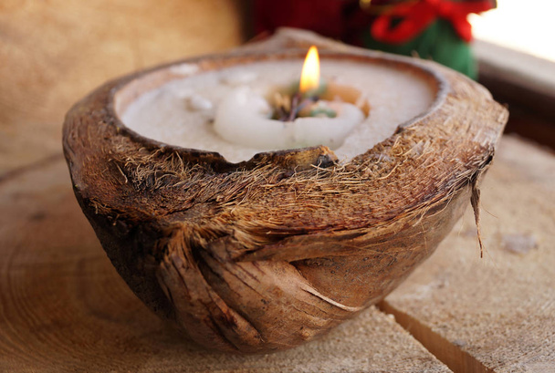Cera decorativa una vela en un coco
 - Foto, Imagen