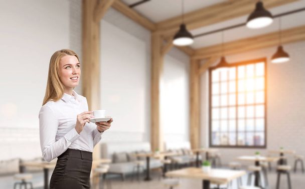 Blond woman standing in cafe - Foto, afbeelding