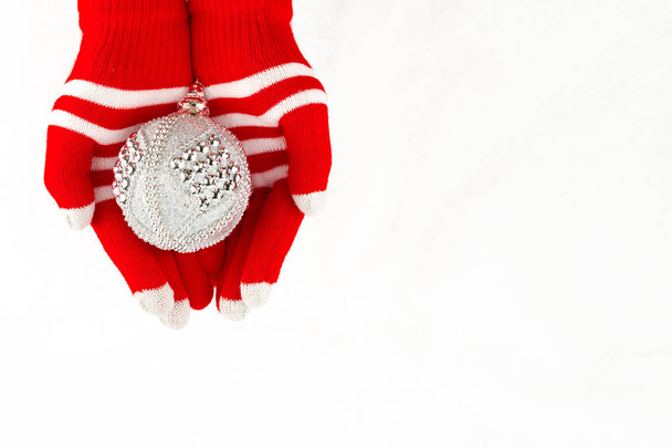 Christmas card, gloves on hands holding silver ball isolated on  - Photo, Image