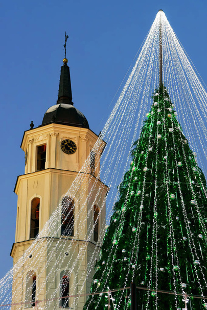 Χριστουγεννιάτικο δέντρο με διακόσμηση και το καμπαναριό του καθεδρικού ναού πλατεία Βίλνιους - Φωτογραφία, εικόνα