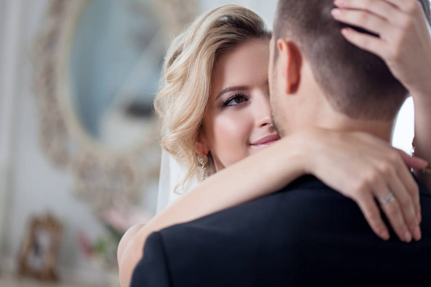Embrace on wedding day. Beautiful bride embracing groom in the neck - Foto, Bild