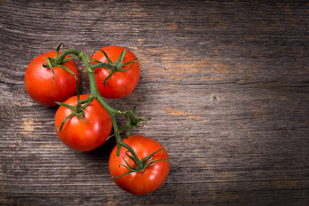 Bunch of tomatoes on the wooden table in natural light - Photo, Image