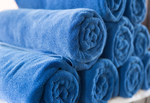 stapel van warmgewalste gevouwen blauwe handdoek in spa - Foto, afbeelding
