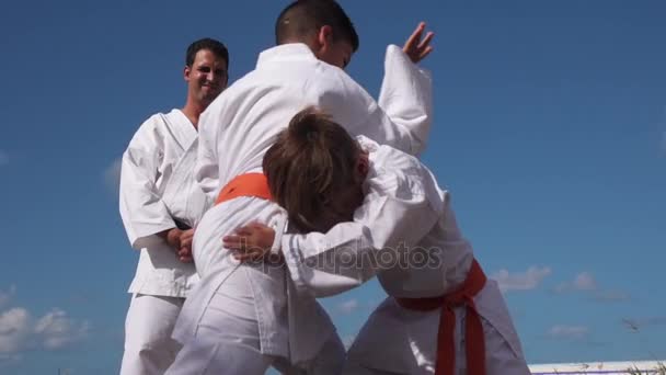 Děti boje na Karate školy a učitel při pohledu na ně - Záběry, video