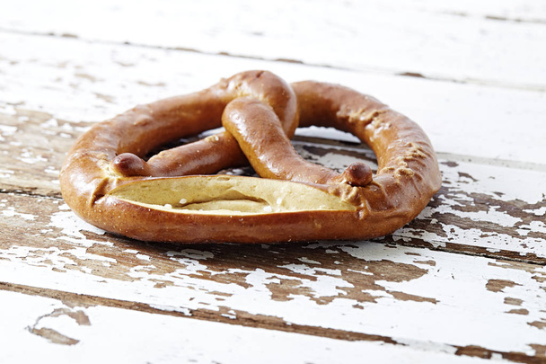 Una imagen de un delicioso pretzel bavariano sobre un fondo de madera
 - Foto, imagen