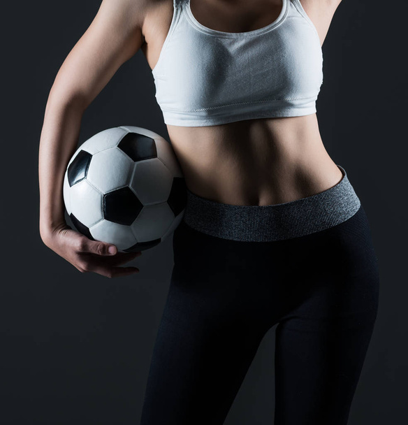 Όμορφη γυναίκα, κρατώντας ένα ποδόσφαιρο γκρι φόντο - Φωτογραφία, εικόνα