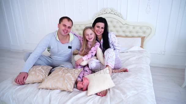 Portre mutlu aile gülümseyen ve kamera yatak ev bakarak pijama - Video, Çekim
