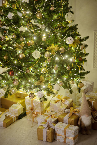 Elegante árbol de Navidad decorado con brillantes bolas de vidrio y luces de hadas
. - Foto, imagen