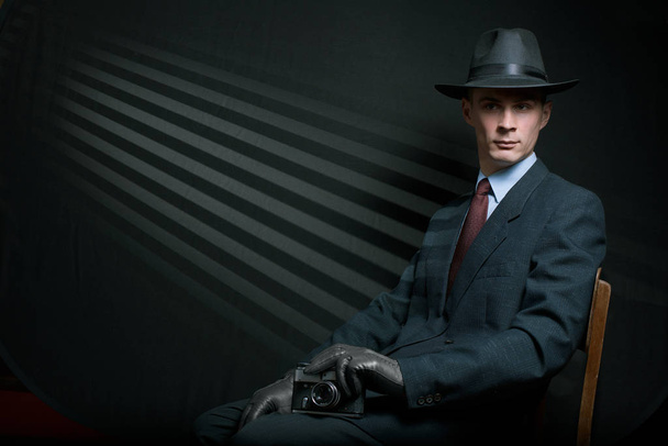Stylish vintage detective posing on a chair - Photo, Image