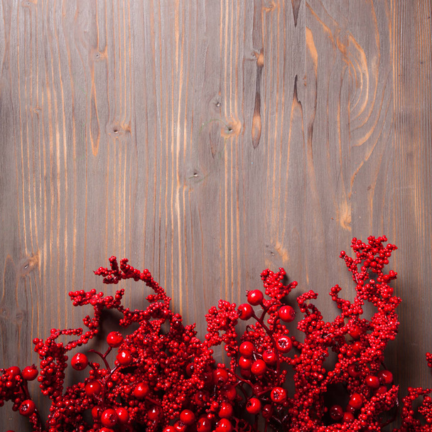 Holly berry twigs on wood wall - Фото, изображение