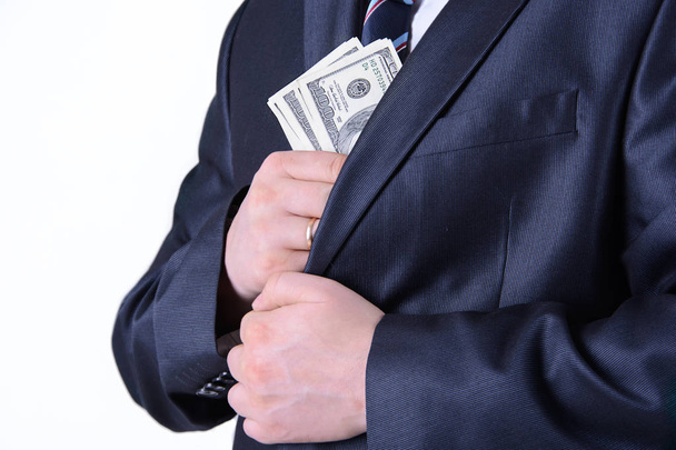 Homme d'affaires mettre de l'argent dans la poche de la veste costume
 - Photo, image