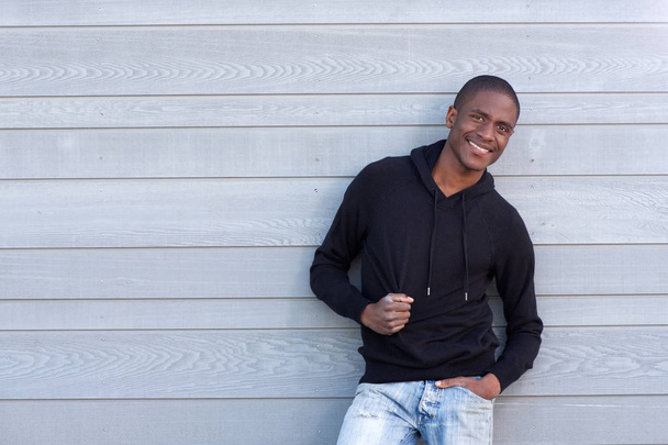Guy glimlachend in zwart sweatshirt - Foto, afbeelding