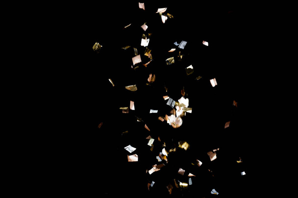 Golden confetti on black background - 写真・画像