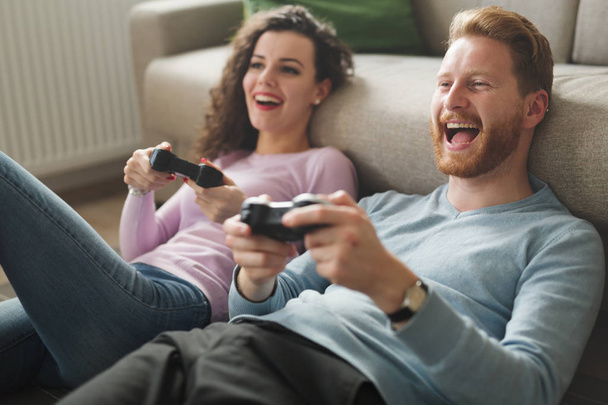 Beautiful couple playing video games on console - Foto, imagen
