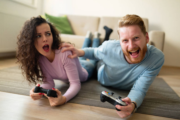 Beautiful couple playing video games on console - Fotoğraf, Görsel
