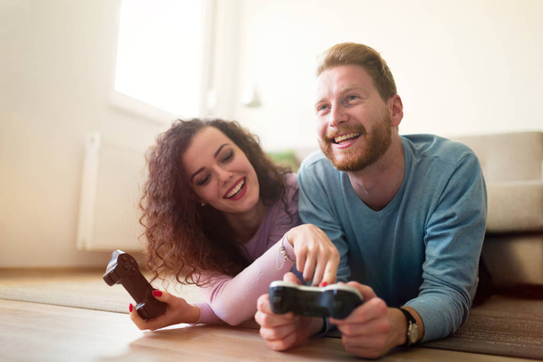 onnellinen pari pelaa videopelejä
 - Valokuva, kuva