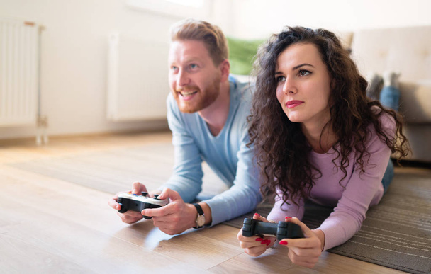 Beautiful couple playing video games on console - Photo, Image