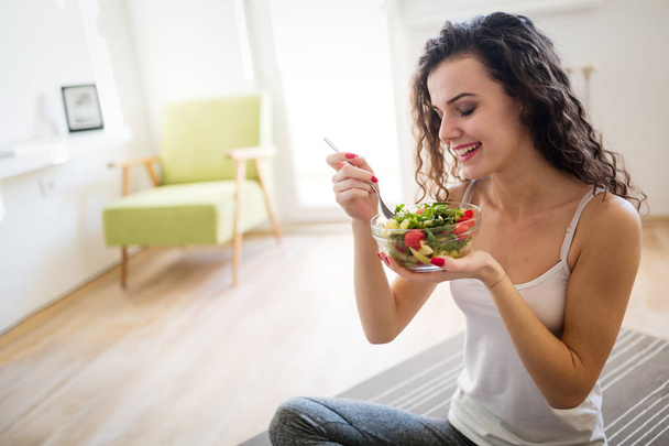 Beautiful woman eating healthy fresh food - Foto, afbeelding