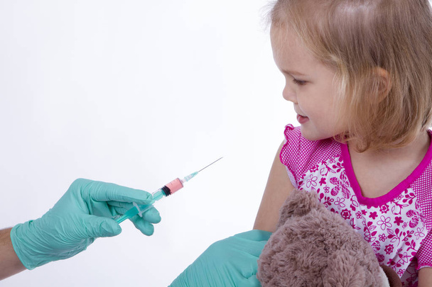 医者が注射接種を保持している小さな女の子 - 写真・画像