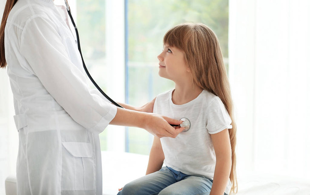 Pediatrician examining little girl - 写真・画像