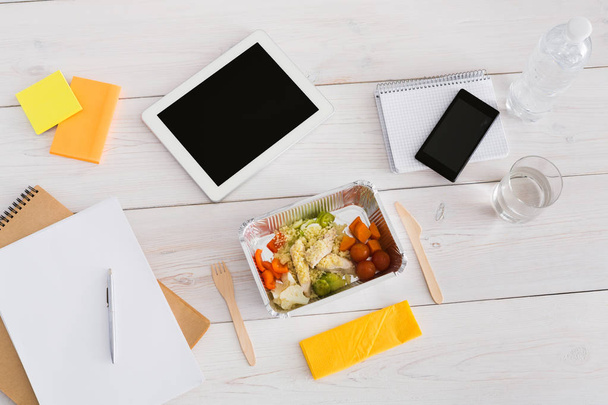 Healthy lunch foil box with diet food on office table - Foto, afbeelding
