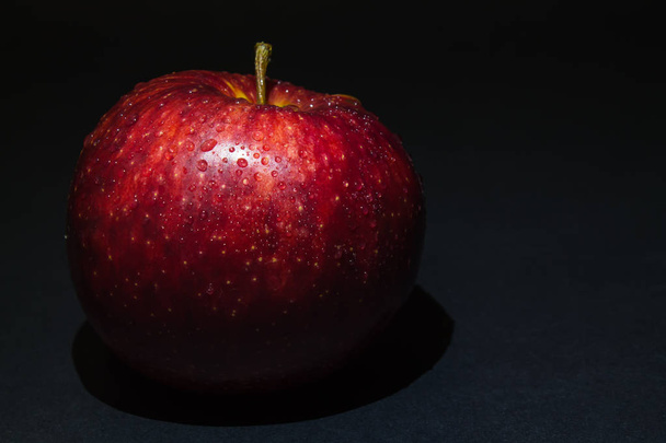 красное яблоко с капельками росы на черном фоне
 - Фото, изображение