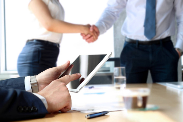 Business partners handshaking over zakelijke objecten op de werkplek. werken met digitale tablet zakenvrouw - Foto, afbeelding