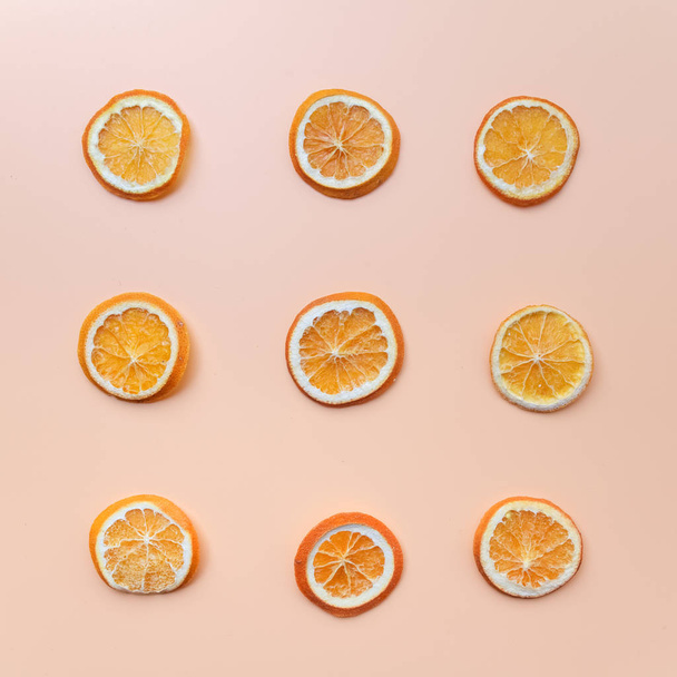 Dried orange slices patterned over green background, top view. Flat lay - Valokuva, kuva