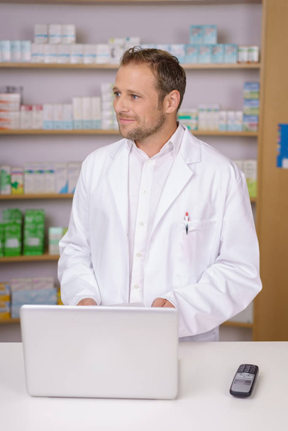 Male pharmacist standing watching someone - Foto, Imagem
