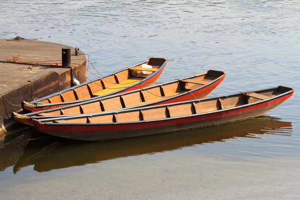Três barcos de rio e barcaças dobradas para cais
 - Foto, Imagem