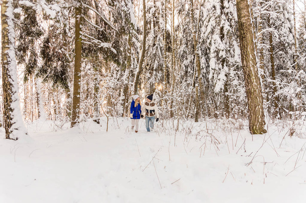 De jongen en het meisje hebben een rust in de bossen van de winter.  - Foto, afbeelding