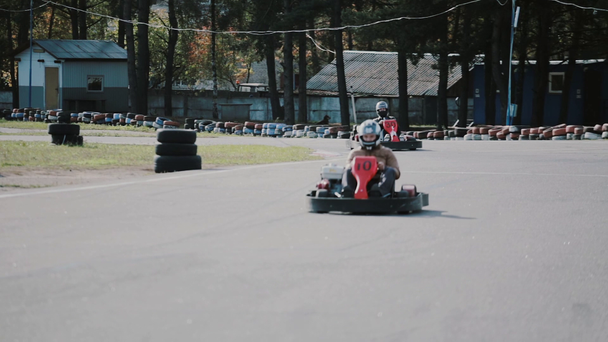 Two drivers on a go-kart track move into the camera and pass it by. Go-kart race. - Footage, Video