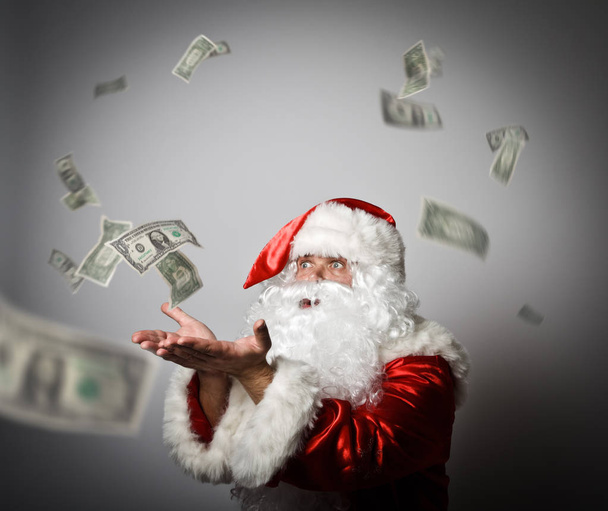 Santa Claus is blowing dollars. - Фото, изображение