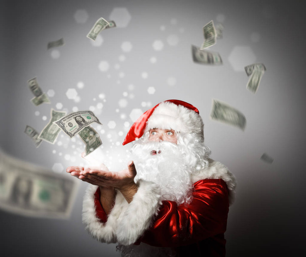 Santa Claus is blowing dollars. - Fotoğraf, Görsel