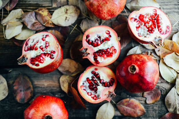 reife Granatapfelfrüchte auf hölzernem Vintage-Hintergrund. roter Saft - Foto, Bild