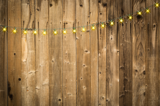 Λαμπερό ξύλινο υπόβαθρο με αλυσίδα από πολύχρωμα λαμπιόνια - Φωτογραφία, εικόνα