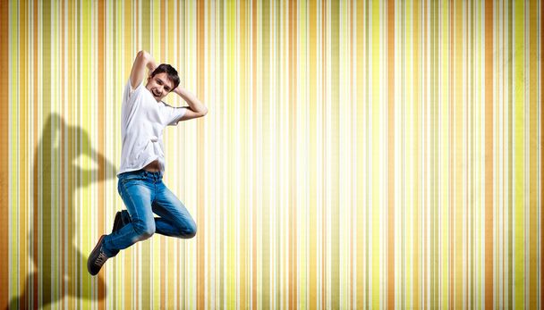 Young man dancing and jumping... - 写真・画像