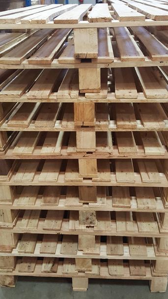paletes de madeira marrom para distribuição e transporte de produtos no armazém
 - Foto, Imagem
