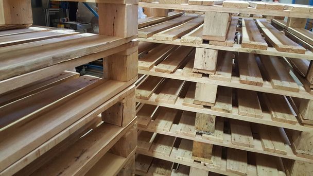 коричневые деревянные поддоны для распределения и транспортировки продукции на складе
 - Фото, изображение