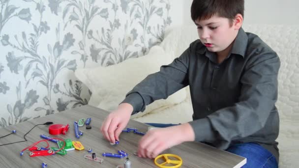 Boy assembles the electrical circuit from constructor - Felvétel, videó