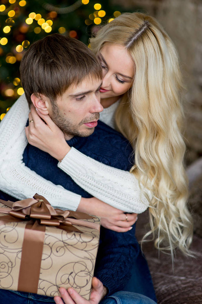 Happy couple of lovers in pullovers give each other gifts - Foto, Imagem