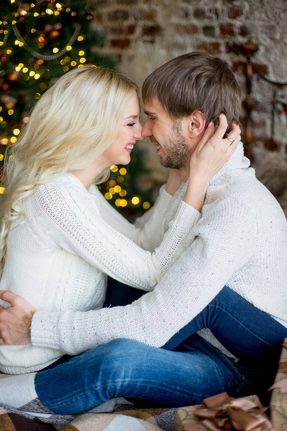 Happy couple of lovers in pullovers look each other sitting - Foto, Imagen
