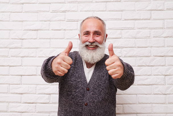 Merry man smiling broadly and showing thumbs-up - Фото, зображення