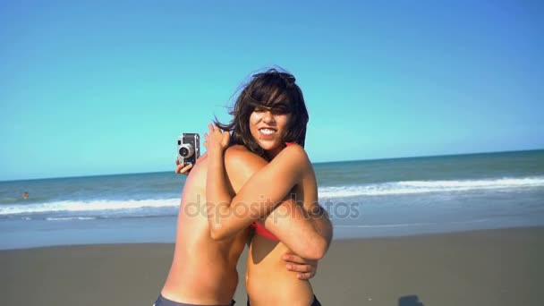 casal tirando uma foto na praia
  - Filmagem, Vídeo